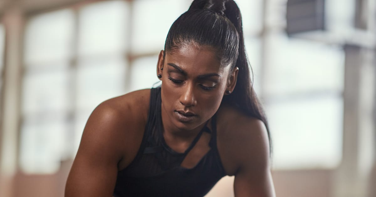 Female athlete A fit-looking female athlete takes a break from a workout, looking tired.